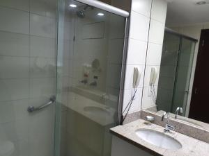 a bathroom with a glass shower and a sink at Flat Beach Class Internacional in Recife