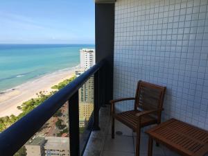a balcony with a chair and a view of the beach at Flat Beach Class Internacional in Recife