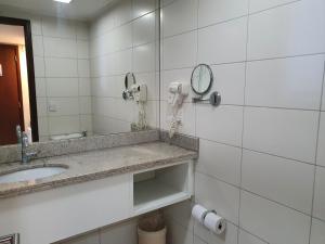 a bathroom with a sink and a mirror at Flat Beach Class Internacional in Recife