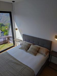 1 dormitorio con 1 cama y ventana grande en Cabañas Alcobas do Sil Ecoturismo, en Parada del Sil