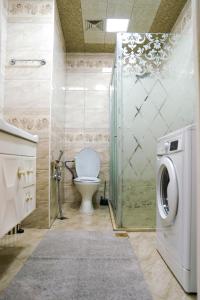 a bathroom with a toilet and a shower with a washing machine at Комфортная квартира возле метро in Baku