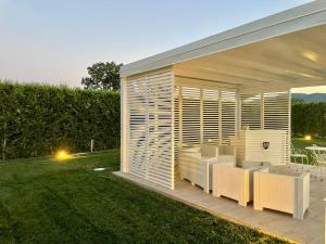 a backyard pavilion with white furniture on a lawn at Ca' Del Conte in Padula