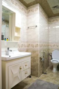 uma casa de banho com um WC, um lavatório e um chuveiro em Комфортная квартира возле метро em Baku