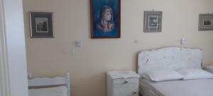 um quarto com uma cama e um quadro na parede em Balcony to Aegeon 4 em Apollon