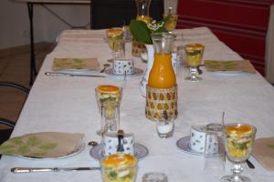 a table with a white table cloth with glasses on it at Chambre d'hôtes Auriac du Périgord in Auriac-du-Périgord +9 photos