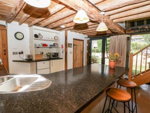 eine Küche mit einer schwarzen Arbeitsplatte und einem Waschbecken in der Unterkunft Tinkley Cottage in Nymphsfield