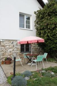 une terrasse avec une table, des chaises et un parasol dans l'établissement Domek u lesa, à Bítov