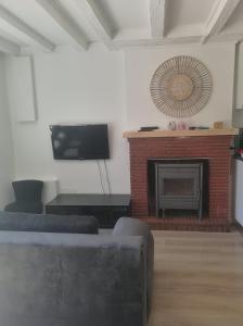 a living room with a fireplace and a tv at L'EssenCiel du Lac in Éguzon-Chantôme