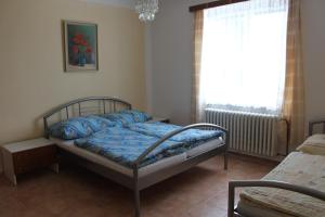una camera da letto con un letto con lenzuola blu e una finestra di Domek u lesa a Bítov