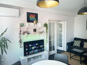 a living room with a tv and a couch at Green peaceful ultra central apartment, 2 bedrooms, Streaming, Workspaces in Cluj-Napoca
