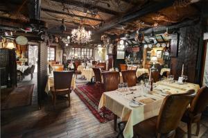 a restaurant with tables and chairs and a chandelier at Crab Manor Hotel in Thirsk