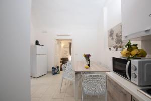 a kitchen with a counter with a table and a microwave at Amalfi 90 - holiday house close the beach in Atrani