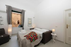 a bedroom with a bed with a flower blanket on it at Amalfi 90 - holiday house close the beach in Atrani