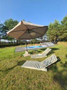 a large umbrella and some chairs and a pool at O!-Kruszek in Kruszka