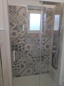 y baño con ducha, ventana y azulejos. en CASE DI BACCO, en Agropoli