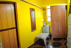 a yellow bathroom with a stool and a yellow wall at selfia guest house majorda in Majorda
