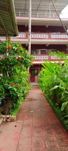 selfia guest house majorda في ماجوردا: ممشى في مبنى به زهور ونباتات