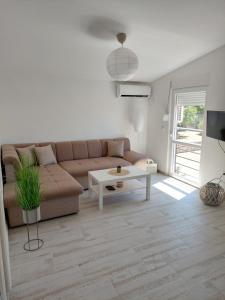 una sala de estar con un sofá y una mesa en Apartmani.Sutomore, en Sutomore