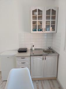 Una cocina con gabinetes blancos y un fregadero. en Apartmani.Sutomore, en Sutomore 24 fotos más