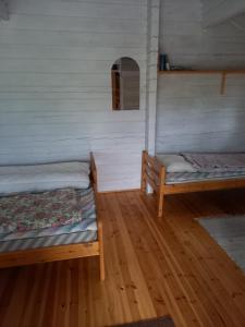 a room with two beds and a wooden floor at Aatami in Kangasniemi