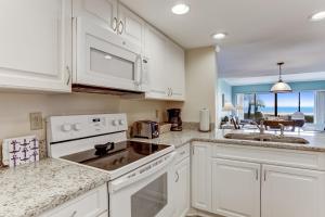 a kitchen with white cabinets and a counter top at Stay Better Vacations Amelia Island-Oceanfront Surf & Racquet C109 in Fernandina Beach