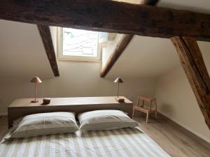 um quarto com uma cama grande e uma janela em BELABRI'- centralissime mansarde charme&comfort CIR 0215-0216 em Aosta