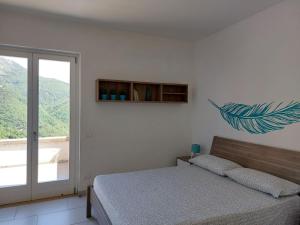 a bedroom with a bed and a large window at Adagio Ravello in Ravello