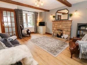 a living room with a fireplace and a mirror at White Swan Cottage in Bakewell