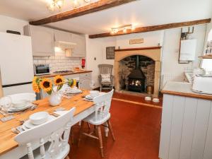 a kitchen and dining room with a table and a fireplace at White Swan Cottage in Bakewell