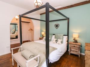 a bedroom with a four poster bed and a mirror at White Swan Cottage in Bakewell