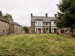 a large house on a grassy field in front of it at White Swan Cottage in Bakewell