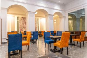 a dining room with tables and blue chairs at Hotel Majestic in Casablanca