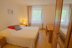 um quarto com uma cama, uma secretária e uma janela em The Village Rest - Brezje Gorenjska em Brezje
