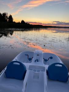 a boat on the water with a sunset in the background at A. Smetonos Dvaro Smetonienės svetainė 