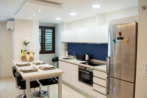 a kitchen with a stainless steel refrigerator and a table at Edificio Ramiro in Marbella