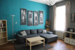 sala de estar con sofá y pared azul en Ferienwohnung zum Eifgental, en Wermelskirchen