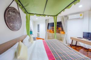 a bedroom with a bed with a green canopy at Nakorn De Sukhothai Hip Hotel in Sukhothai