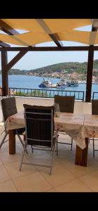 a table and chairs on a patio with a view of the water at Apartmani Mia in Kali