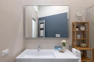 a bathroom with a large mirror and a white sink at iFlat Lovely and comfortable flat in Prati in Rome