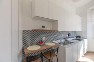 a kitchen with a sink and a counter with stools at iFlat Lovely and comfortable flat in Prati in Rome