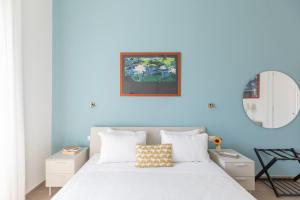 a bedroom with a white bed with a blue wall at iFlat Lovely and comfortable flat in Prati in Rome