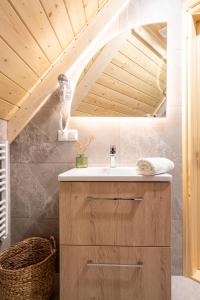 baño con lavabo y techo de madera en Highlander Heart Residence, en Zakopane