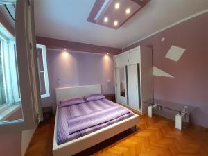 Un dormitorio con una cama con sábanas moradas. en Apartments Cebalo - Ekonomija, en Korčula