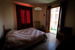 a bedroom with a bed and a large window at Alloggio nel centro storico in Frabosa Soprana