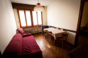 a living room with a table and a red couch at Alloggio nel centro storico in Frabosa Soprana