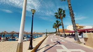 una calle junto a una playa con palmeras y luz de la calle en Casa Todo Verde-A Murcia Holiday Rentals Property, en Los Alcázares