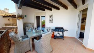 un patio con mesa, sillas y parrilla en Penthouse Anchoa-A Murcia Holiday Rentals Property, en Roldán