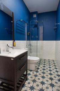 La salle de bains est pourvue d'un lavabo, de toilettes et de murs bleus. dans l'établissement Buxus Hotel Shekvetili, à Shekvetili