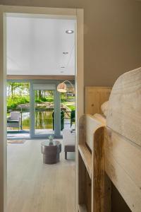 a bedroom with a bunk bed and a living room at Houseboats Pean-buiten Weidum in Weidum