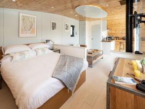 a bedroom with a large bed and a kitchen at Low Longlands in Cartmel